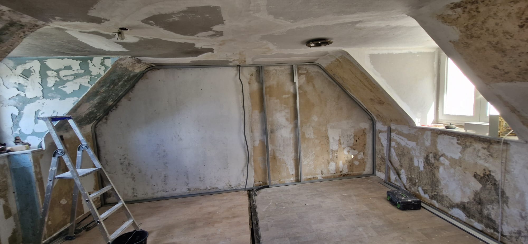 Aménagement de combles : pose de l'ossature métallique sur murs anciens avant placo