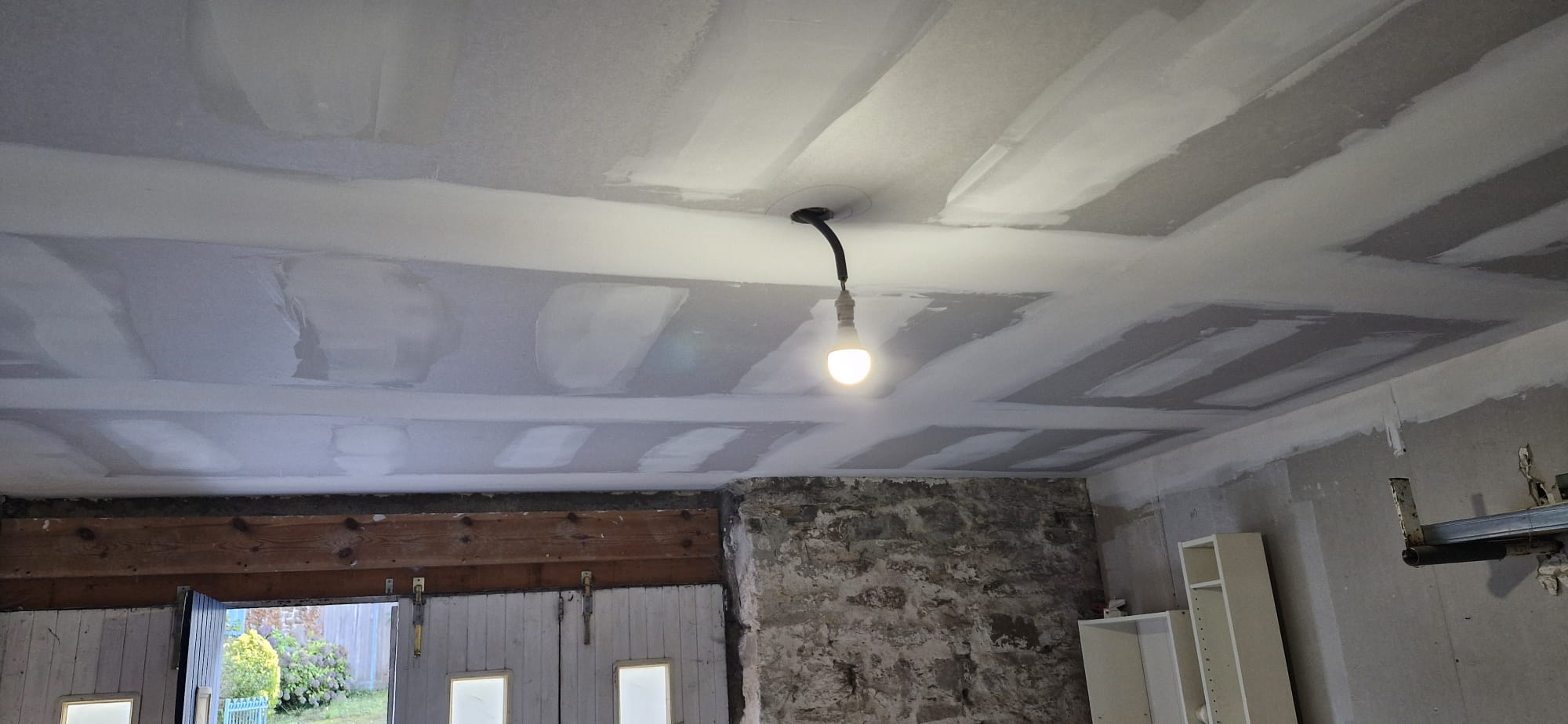 Bandes et joints sur plafond placo entre poutres bois anciennes et mur en pierre — rénovation de longère