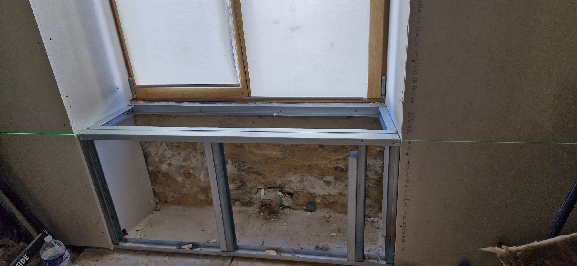 Doublage placo sur ossature métallique autour d'une fenêtre bois avec mur en pierre apparente